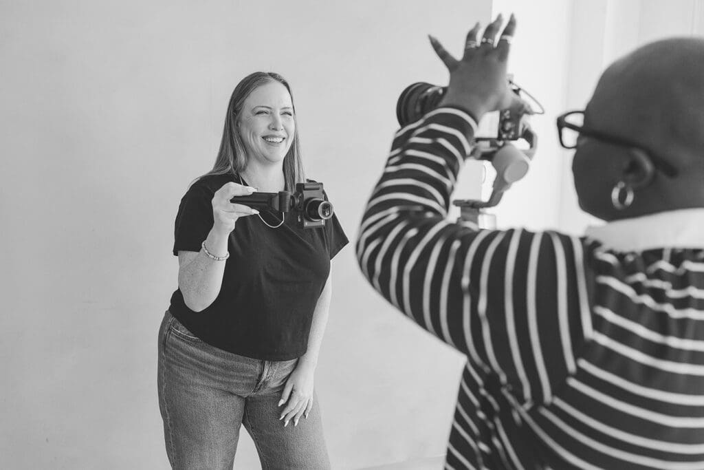 girl smiling holding camera filming content Content creator filming Instagram content to repurpose for TikTok